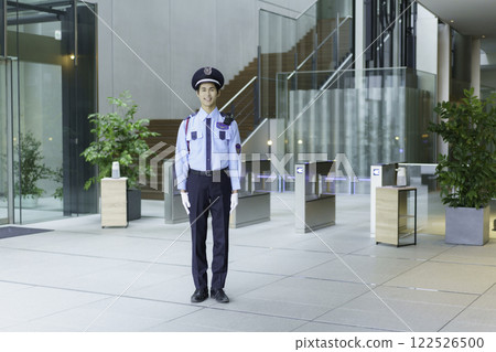 一名年輕的保全站在辦公大樓入口大廳。 122526500