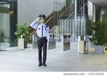 A young security guard saluting while standing in the entrance lobby of an office building. Photo courtesy of Sky Perfect Tokyo Media Center. A young security guard saluting while standing in the entrance lobby of an office building. Photo courtesy of Sky Perfect Tokyo Media Center. 122526501