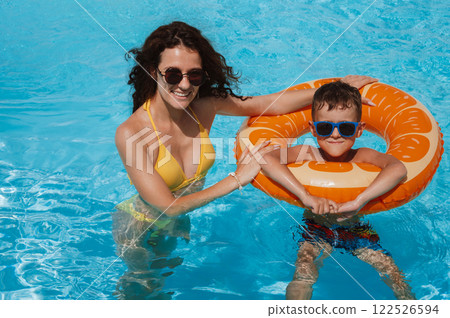 happy young mother and child boy son in swimming pool at a hotel on vacation at a resort in summer 122526594