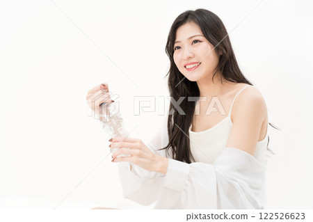 A young woman trying to open a plastic bottle 122526623