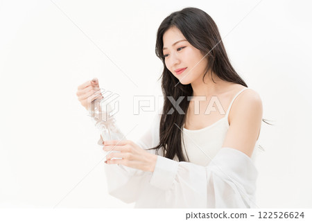 A young woman trying to open a plastic bottle 122526624