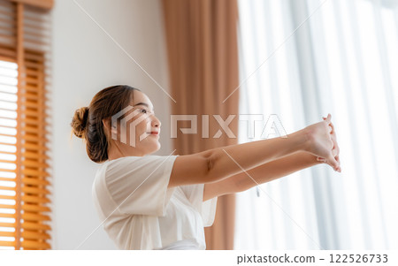 Young Asian beautiful woman doing stretch in the morning at home. Health care and body care concept 122526733