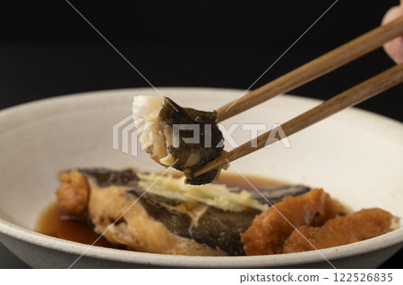 用筷子夾起煮熟的比目魚子 用筷子夾起煮熟的比目魚子 122526835