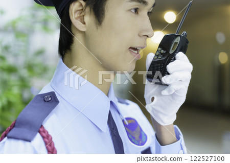 A young security guard talking on a walkie-talkie in an office building. Photo courtesy of Sky Perfect TV Tokyo Media Center 122527100