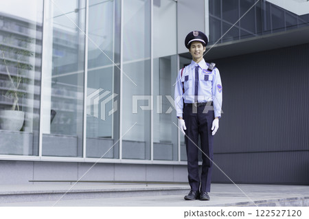 一名年輕的保全站在辦公大樓外。 122527120