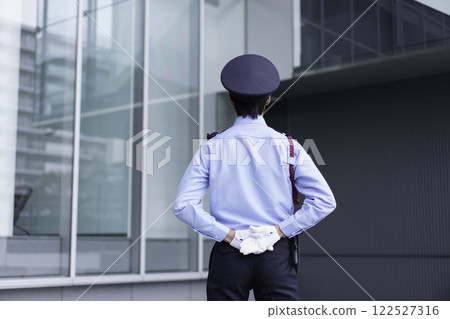 The back view of a young security guard standing outside an office building. Photo courtesy of Sky Perfect Tokyo Media Center. 122527316