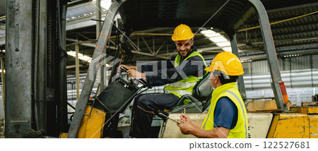 Two men in yellow safety vests are in a forklift cab 122527681