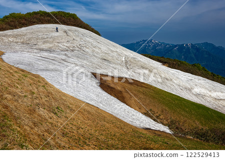 Climbers walking along the snowy valley of the Asakusa ridgeline and a view of Mt. Sumon Climbers walking along the snowy valley of the Asakusa ridgeline and a view of Mt. Sumon 122529413