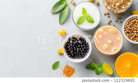 Assortment of ingredients for making bubble tea, including tapioca pearls, milk, fruit, and tea. 122529685