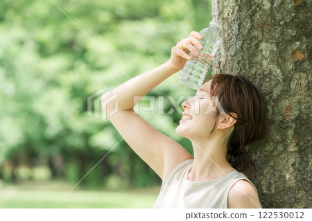 一名婦女在森林裡喝水(補水、礦泉水、鈉) 一名婦女在森林裡喝水(補水、礦泉水、鈉) 122530012