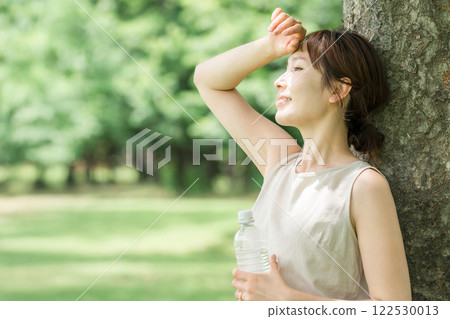 一名婦女在森林裡喝水（補水、礦泉水、鈉） 122530013