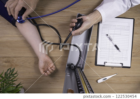 Doctor measuring a patient's blood pressure Medical image Doctor measuring a patient's blood pressure Medical image 122530454