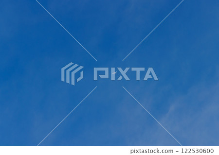 一架飛機在藍天和薄雲之間飛行 122530600