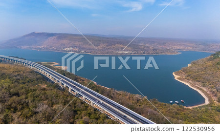 Drone shot aerial view landscape of the M6 motorway Expressway Nakhon Ratchasima Province - Bang Pa-in. Lam Ta Khong River and Mountain. Drone shot of scenic landscape rural place traffic. Nakhon Drone shot aerial view landscape of the M6 motorway Expressway Nakhon Ratchasima Province - Bang Pa-in. Lam Ta Khong River and Mountain. Drone shot of scenic landscape rural place traffic. Nakhon 122530956