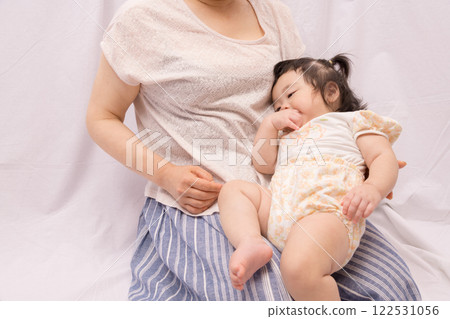 [Baby with twin tails being held by grandmother] 122531056