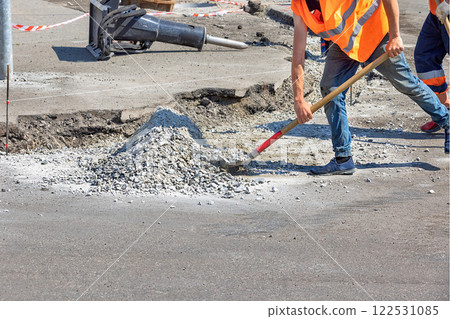 Construction workers engaged in road repair activity on a sunny day. Copy space. 122531085