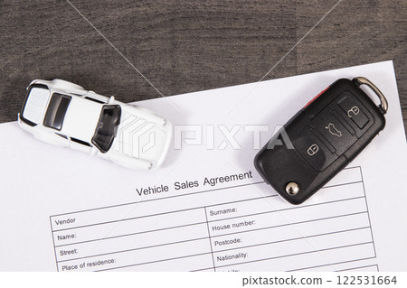 White toy car, car key and vehicle sales agreement. Sales or purchases new or used vehicle 122531664