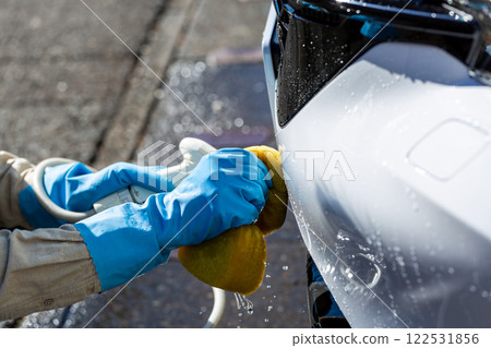 一名男子在自家停車場洗車 一名男子在自家停車場洗車 122531856