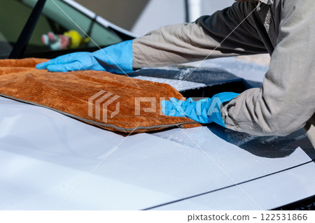 A man washing his car in his home parking lot A man washing his car in his home parking lot 122531866