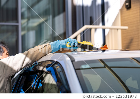 A man washing his car in his home parking lot A man washing his car in his home parking lot 122531978