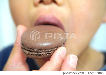 Boy munching on macaroons Boy munching on macaroons 122532088