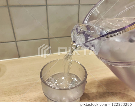 Water being poured into a glass Ice water being poured into a glass 122533290