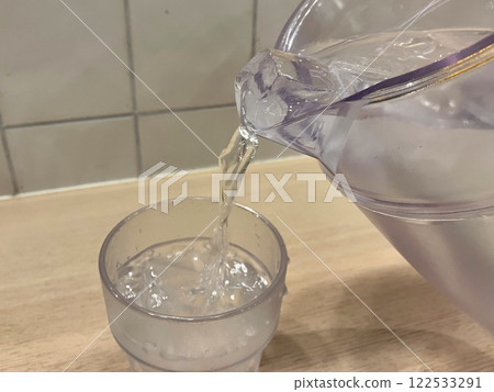 Water being poured into a glass Ice water being poured into a glass 122533291