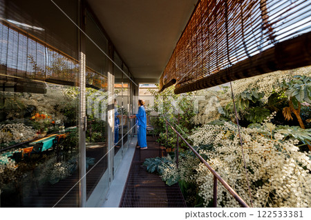 Woman Meditating on Green Balcony 122533381