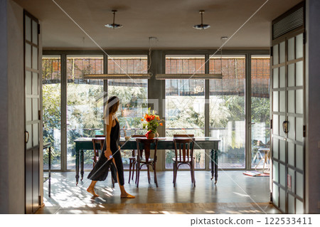 Woman Walking Through Bright Modern Interior 122533411