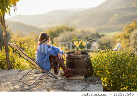 Woman Relaxing on Rustic Patio Woman Relaxing on Rustic Patio 122533540