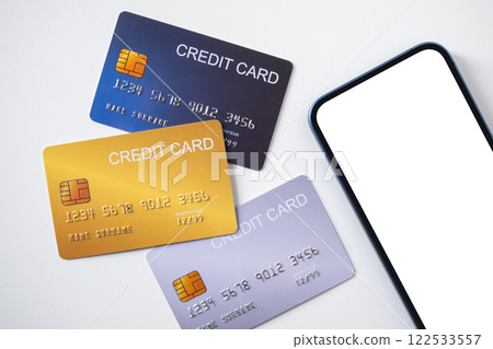 Pile of credit cards with smartphone on white background. Cashless technology and credit card payment concept. 122533557