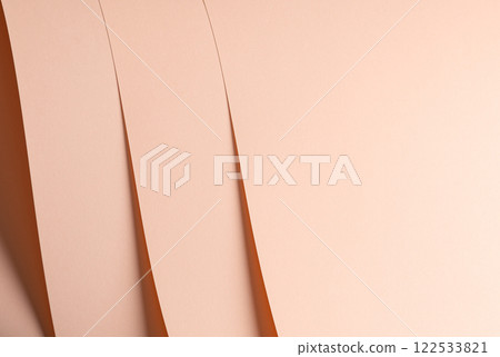 A soft pink and peach paper background with a smooth, matte texture. The gentle pastel tones create 122533821
