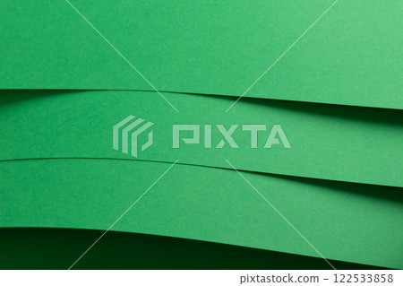 Eden green paper background with layered, curved sheets and a smooth matte finish. Vibrant, soft 122533858