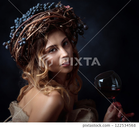 Beautiful blonde with long, wavy hair holding a glass of red wine. 122534568