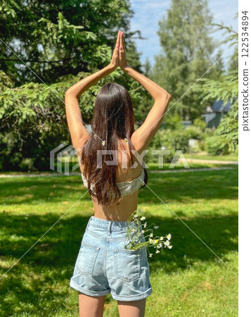 girl with long black hair practices yoga 122534894