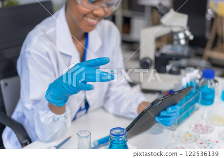 Healthcare professional holding vaccine in laboratory study and analyze scientific sample of  antibody. 122536139