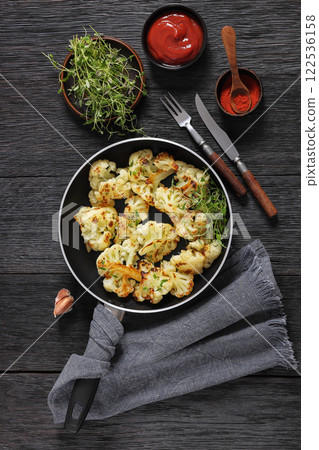 fried cauliflower florets on a skillet, top view fried cauliflower florets on a skillet, top view 122536158