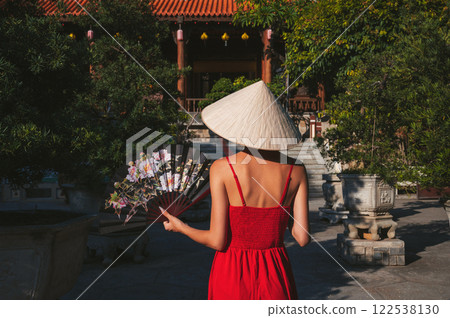back of beautiful young woman tourist with fan in Non La hat in travel in Vietnam 122538130