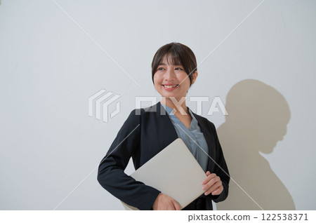 拿著筆記型電腦的微笑的日本女商人 122538371