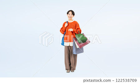 Full-body photo of a stylish middle-aged woman walking with a shopping bag Full-body photo of a stylish middle-aged woman walking with a shopping bag 122538709