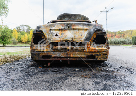 Burned car wreck abandoned on roadside in nature Burned car wreck abandoned on roadside in nature 122539501