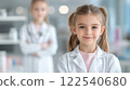 Young girls dressed as scientists in laboratory setting, smiling confidently 122540680