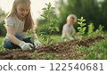 Children planting young plants in garden, enjoying nature and teamwork 122540681