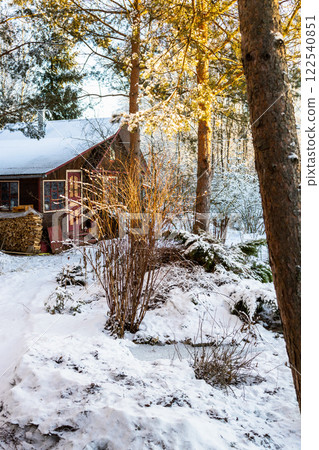 view of wooden hut with woodpile in snowy yard 122540851