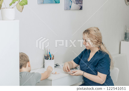speech therapist engaging with boy in nonverbal communication training, concept of education and cognitive skills development 122541051