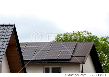 Installing a Solar Cell on a Roof. Solar panels on roof. Historic farm house with modern solar panels on roof and wall. High quality photo 122543411