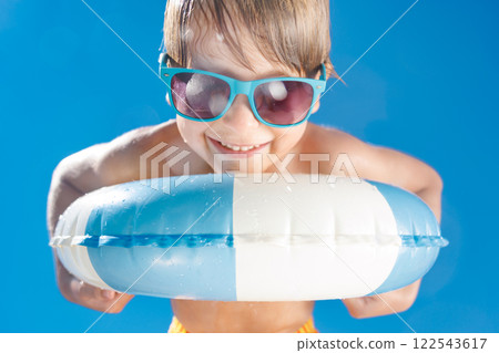 Happy child playing in waterpark. Kid having fun on summer vacation 122543617