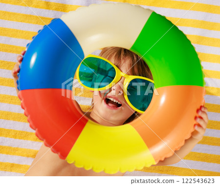 Top view portrait of happy child lying on beach towel on summer vacation 122543623