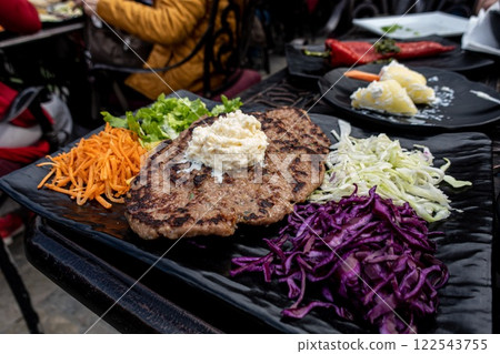 Pleskavica with Kaymak in Prizren, Kosovo. Cabbage and vegetables. 122543755