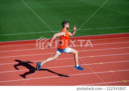 sportsman man in sportswear run fast sprinting on running track, energy 122543807